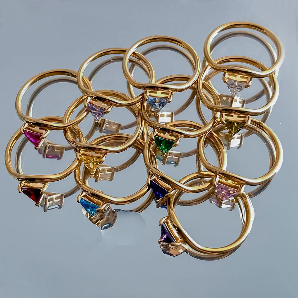 Anillo dorado con piedra de nacimiento triangular 