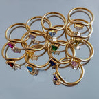 Anillo dorado con piedra de nacimiento triangular 