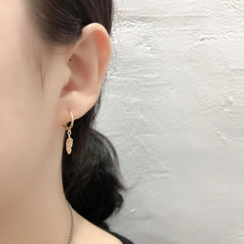 Pendientes de aro con pequeña pluma colgante dorada