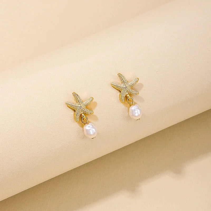 Pendientes dorados con concha, estrella de mar y perla