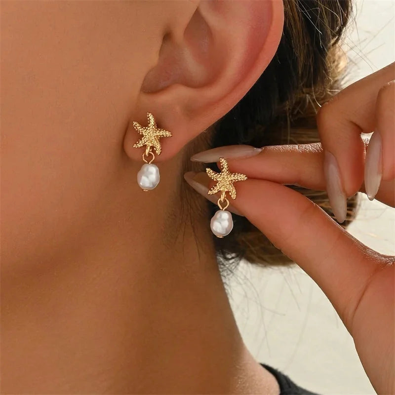 Pendientes dorados con concha, estrella de mar y perla