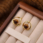 Gold wavy earrings with tiger's eye-effect beads