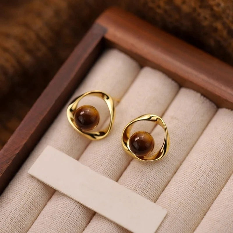 Gold wavy earrings with tiger's eye-effect beads