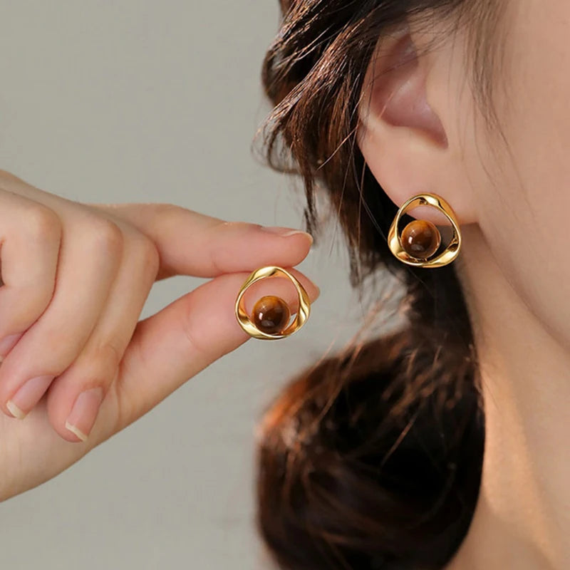 Gold wavy earrings with tiger's eye-effect beads