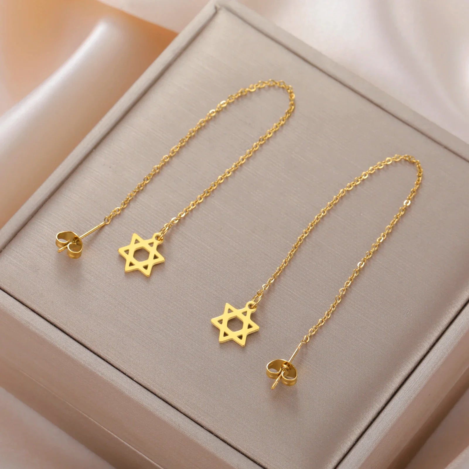 Pendientes largos colgantes con la <span data-glossary-id="etoile_de_david">estrella de David</span> símbolo judío oro