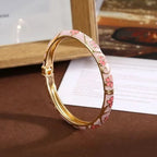 Pulsera con motivos florales y de follaje en esmalte de color rosa 