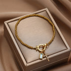 Pulsera con cruz y piedra de nacimiento