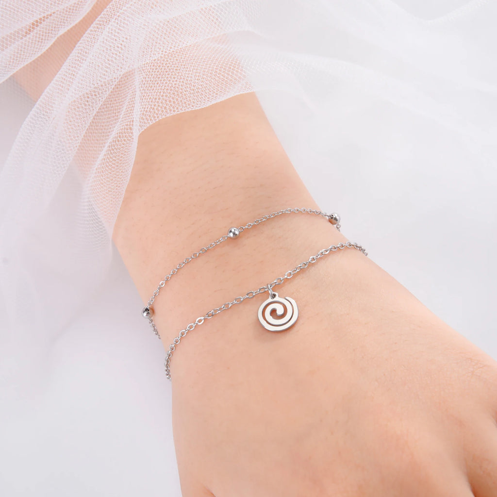Pulsera dorada con pequeña hechura espiral de plata