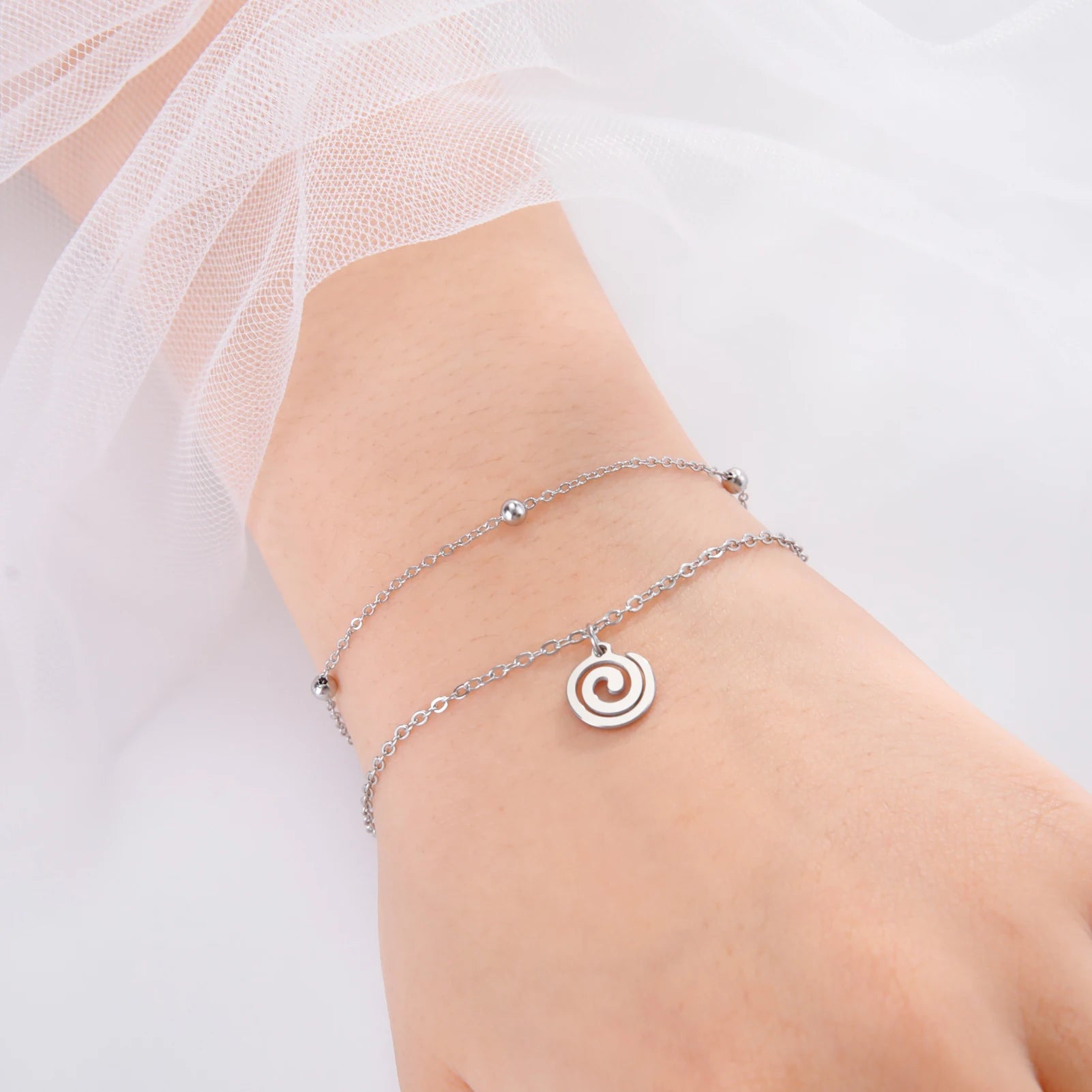 Pulsera dorada con pequeña hechura espiral de plata