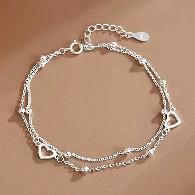 Pulsera de doble corazón y perlas