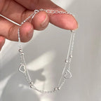 Pulsera de doble corazón y perlas