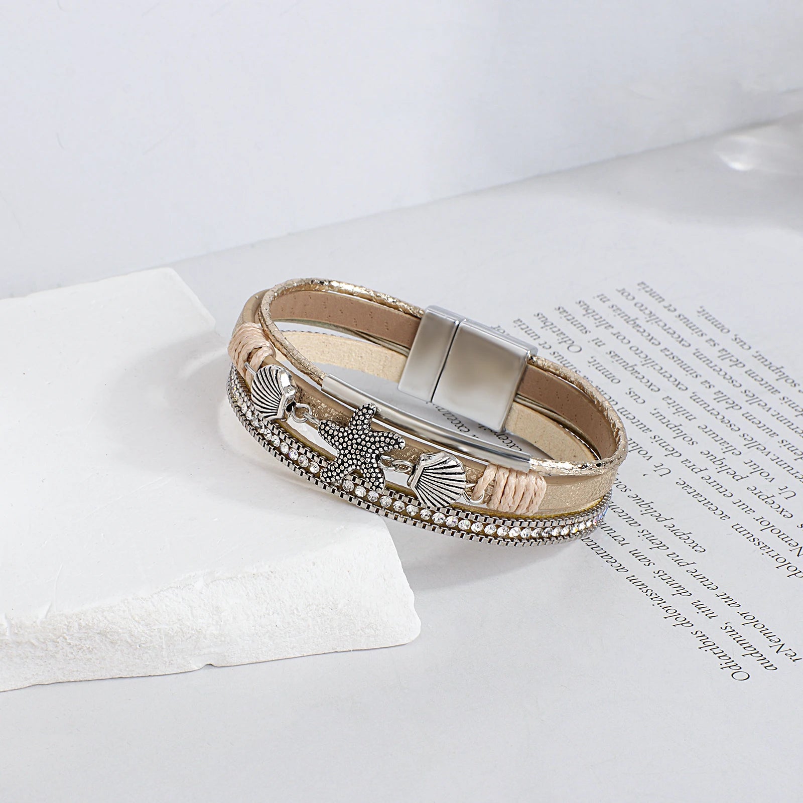 Pulsera de cuero con concha y estrella de mar en oro blanco
