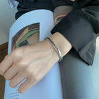 Pulsera rígida abierta con pluma plateada