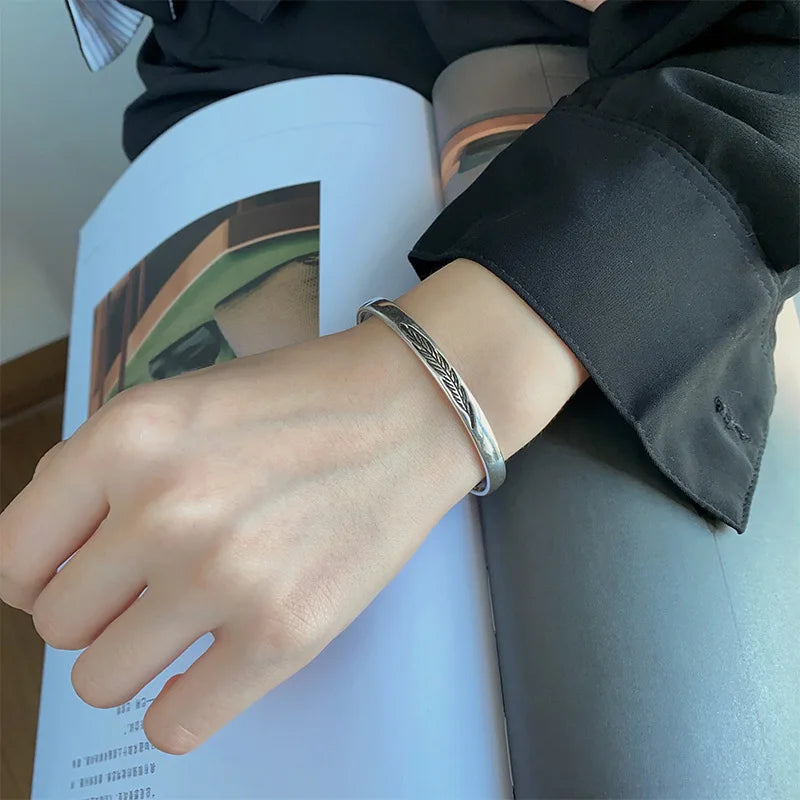 Pulsera rígida abierta con pluma plateada