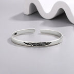 Pulsera rígida abierta con pluma plateada