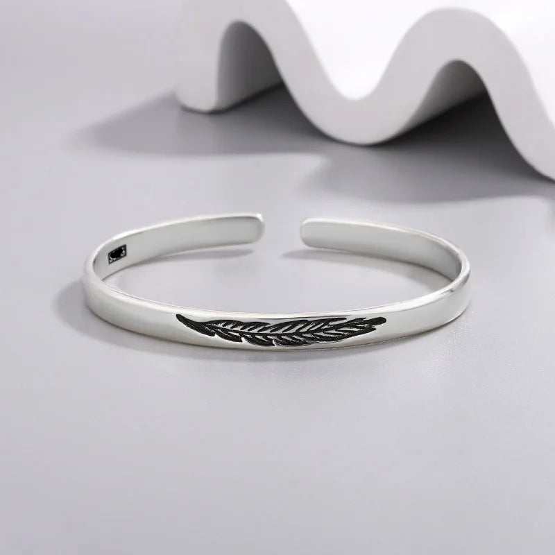 Pulsera rígida abierta con pluma plateada