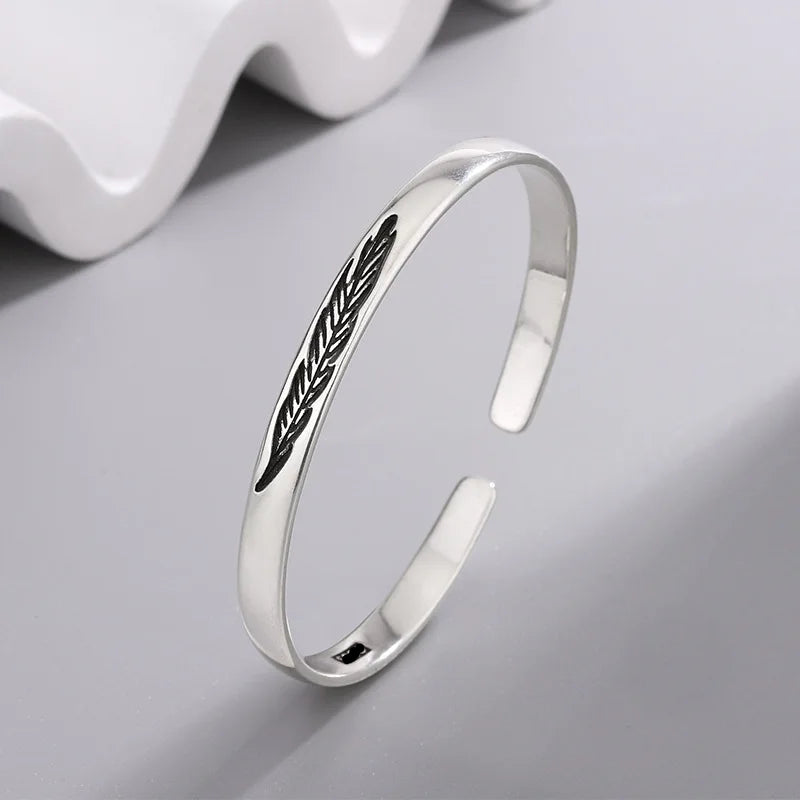 Pulsera rígida abierta con pluma plateada