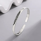 Pulsera rígida abierta con pluma plateada