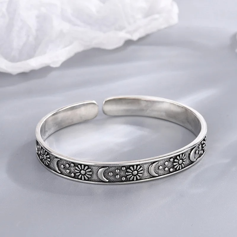 Open antique-style bracelet with engraved suns and crescent moons