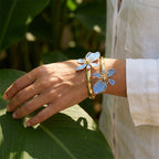 Pulsera abierta adornada con flores exóticas azules