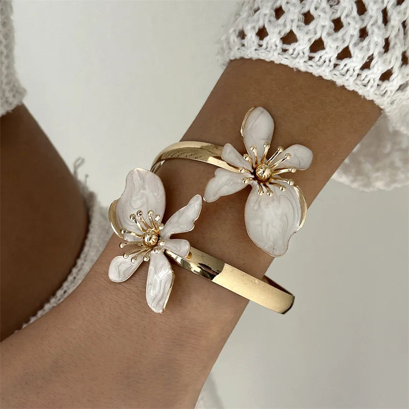 Pulsera abierta adornada con flores exóticas blancas