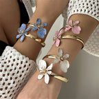 Pulsera abierta adornada con flores exóticas blancas