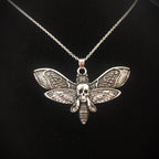 Collar con colgante de mariposa esfinge y calavera 
