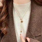 Tie necklace with sunburst charms and tiger's eye stones