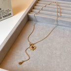 Tie necklace with sunburst charms and tiger's eye stones