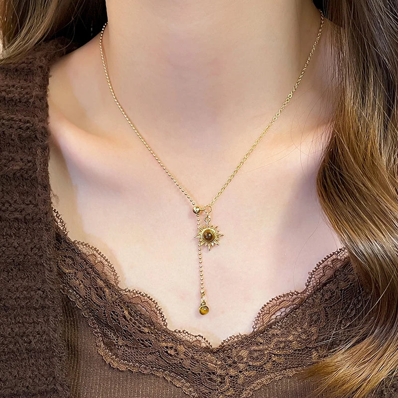 Tie necklace with sunburst charms and tiger's eye stones