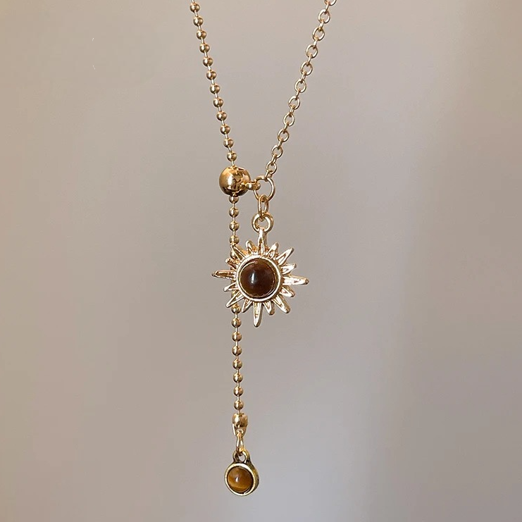 Gold tie necklace with sunburst charms and tiger's eye stones