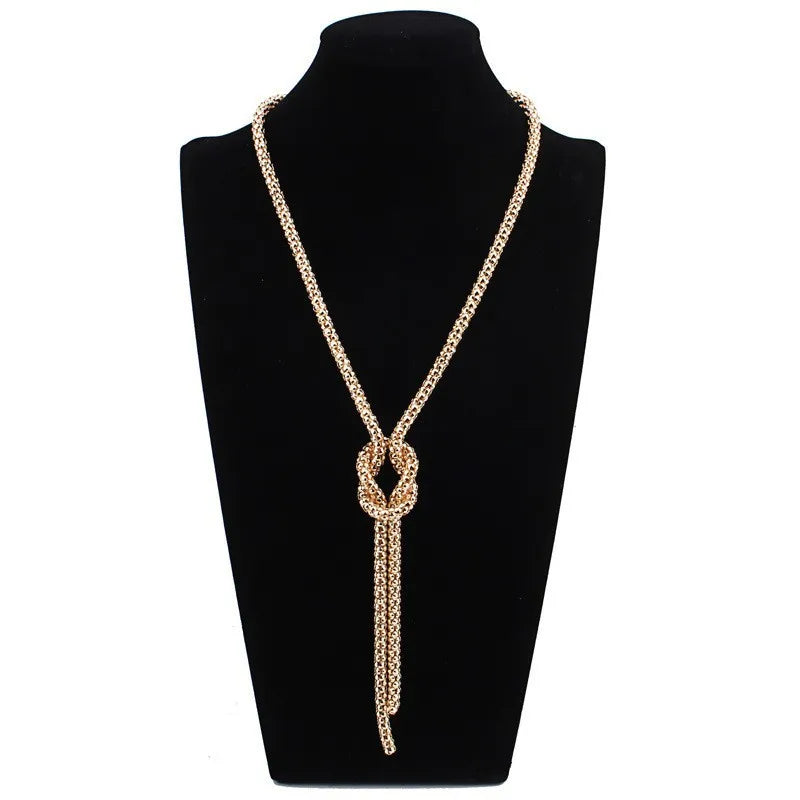 Collar largo con colgante de nudo dorado