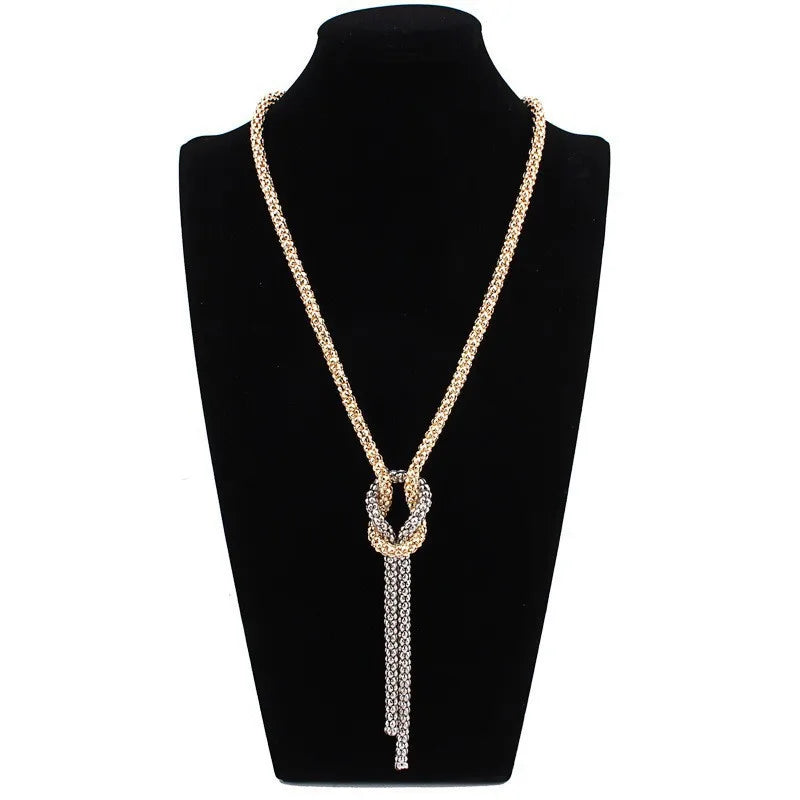 Collar largo con colgante de nudo dorado y plata