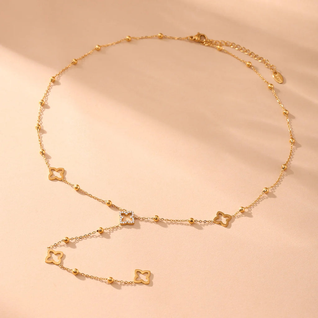 Collar largo con colgantes de trébol de 4 hojas y circonio dorado