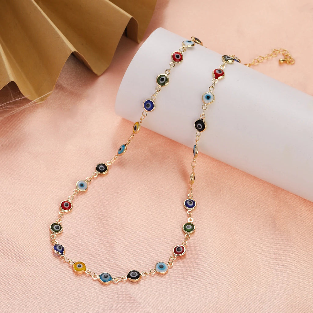 Gargantilla adornada con múltiples colgantes de ojo azul multicolor en tonos neutros