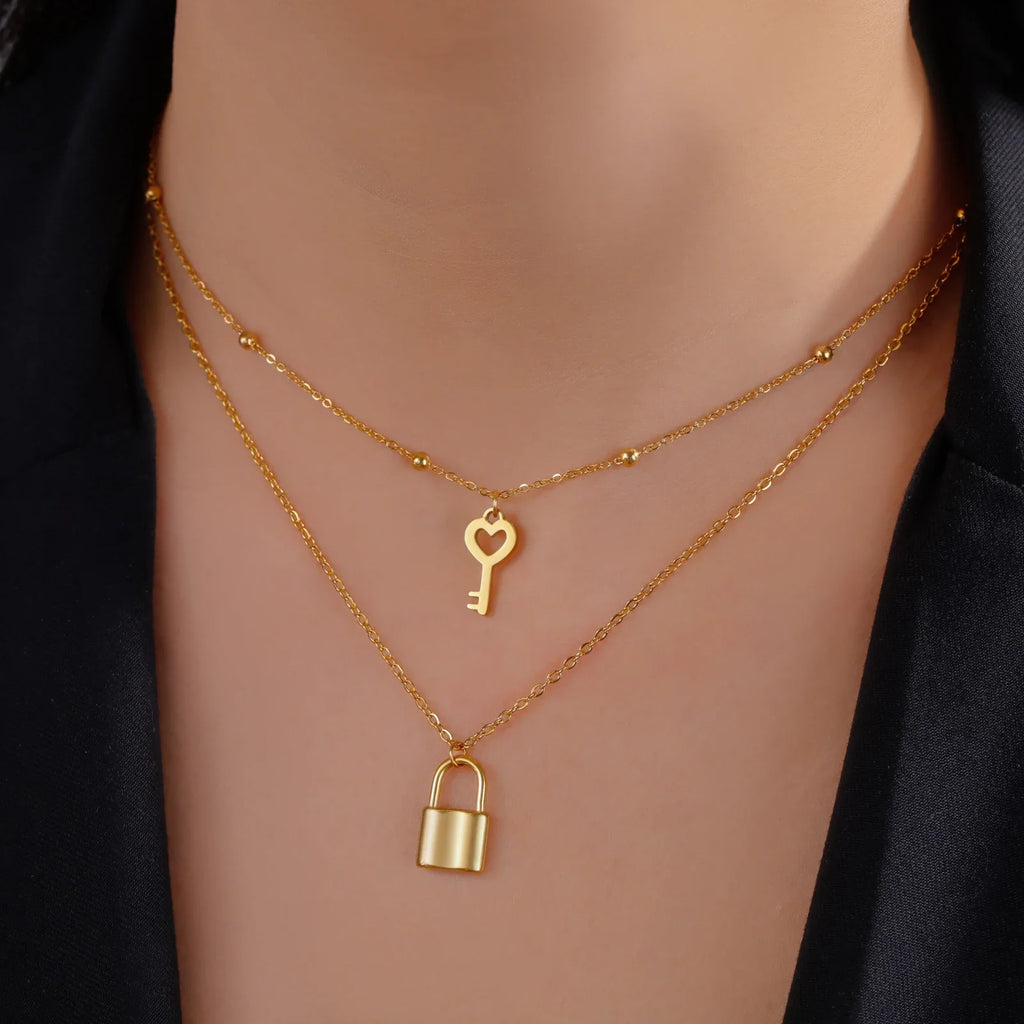 Collar doble con colgante de llave y candado dorado