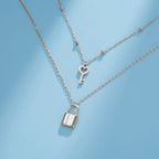 Collar doble con colgante de llave y candado plateado