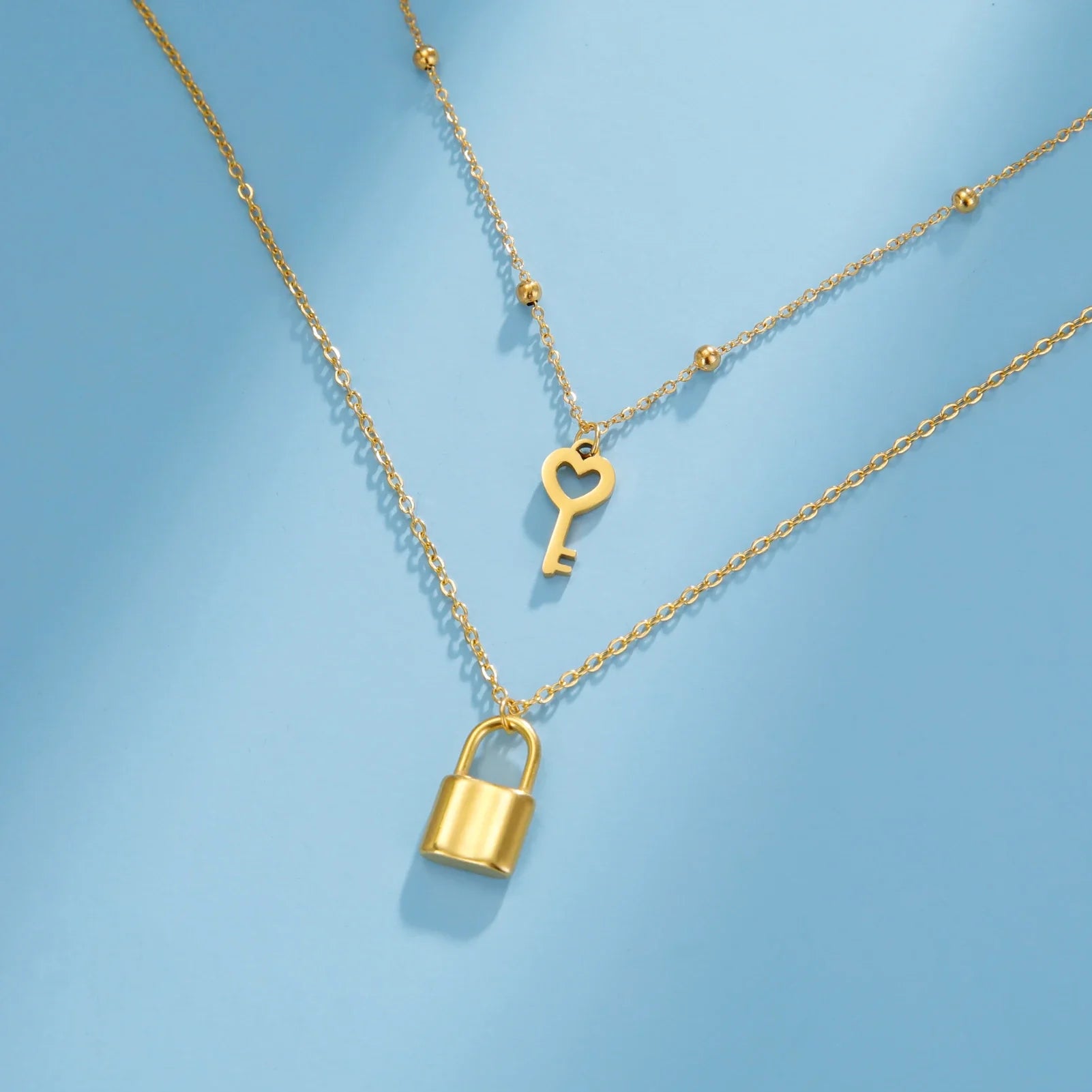 Collar doble con colgante de llave y candado dorado