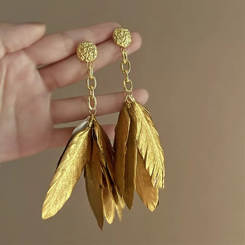 Pendientes grandes con plumas doradas