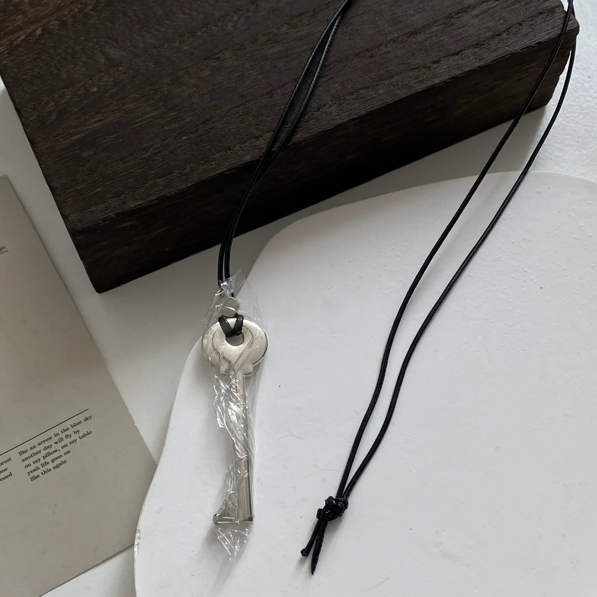 Collar largo de cordón con colgante de llave plata brillante