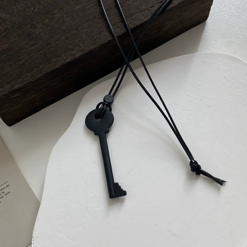 Collar largo de cordón con colgante de llave negra