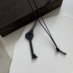 Collar largo de cordón con colgante de llave negra