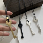 Collar largo de cordón con colgante de llave dorada