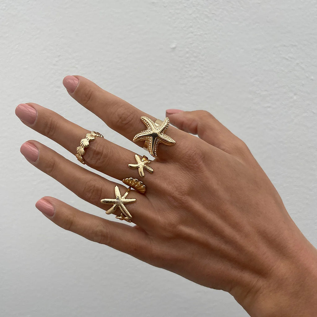 Lote de 4 anillos de conchas y estrellas de mar dorados