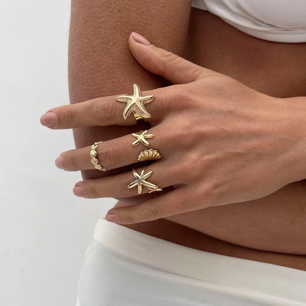 Lote de 4 anillos de conchas y estrellas de mar dorados