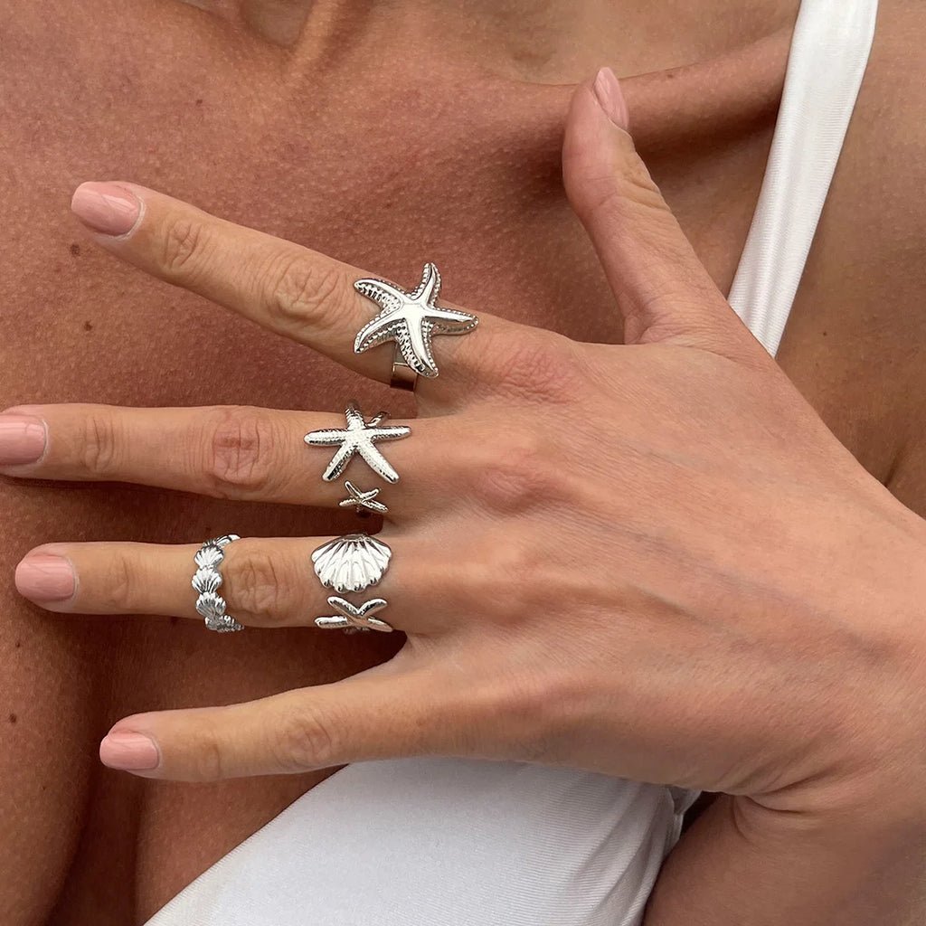Lote de 4 anillos de conchas y estrellas de mar plateados