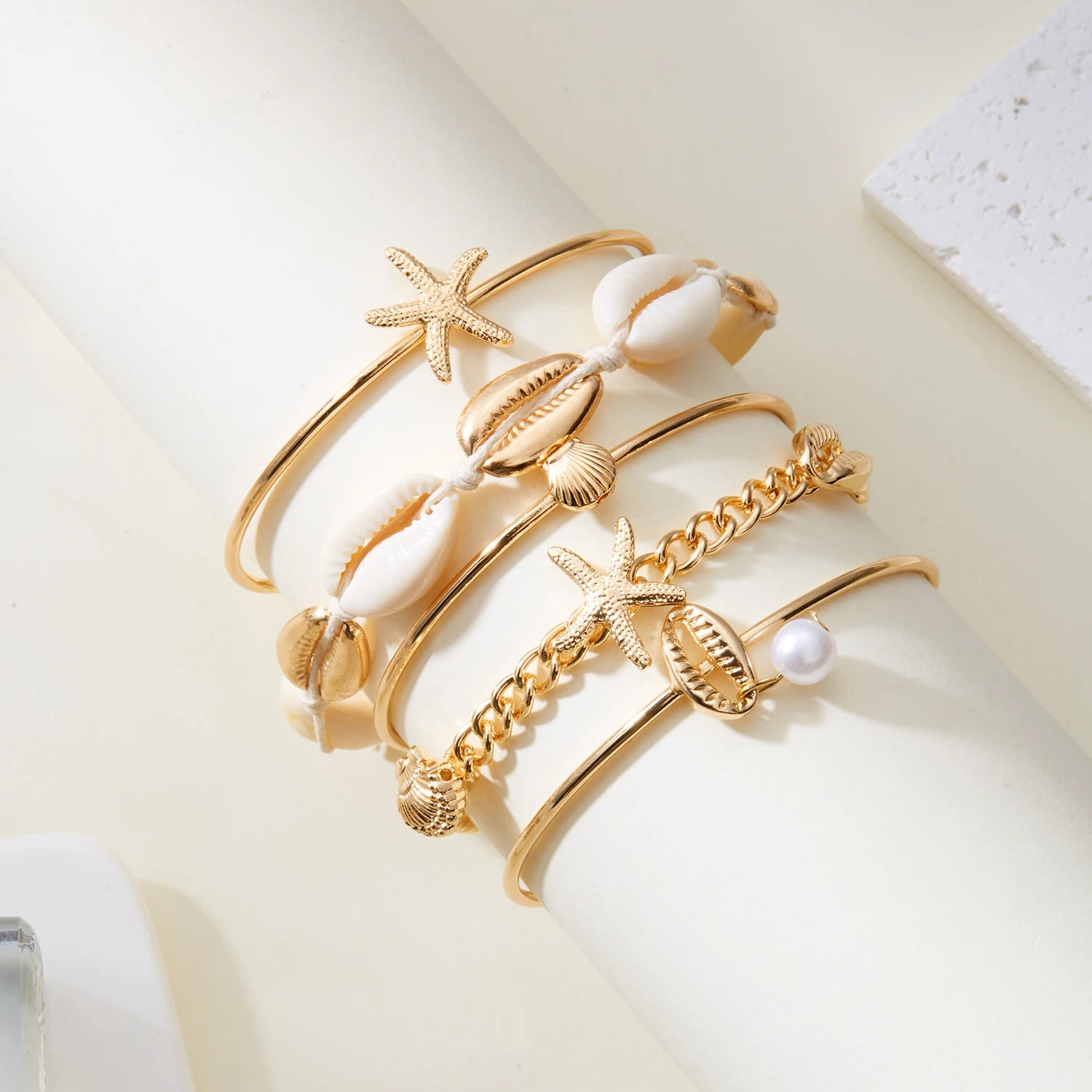 Lote de 5 pulseras con conchas y estrellas doradas