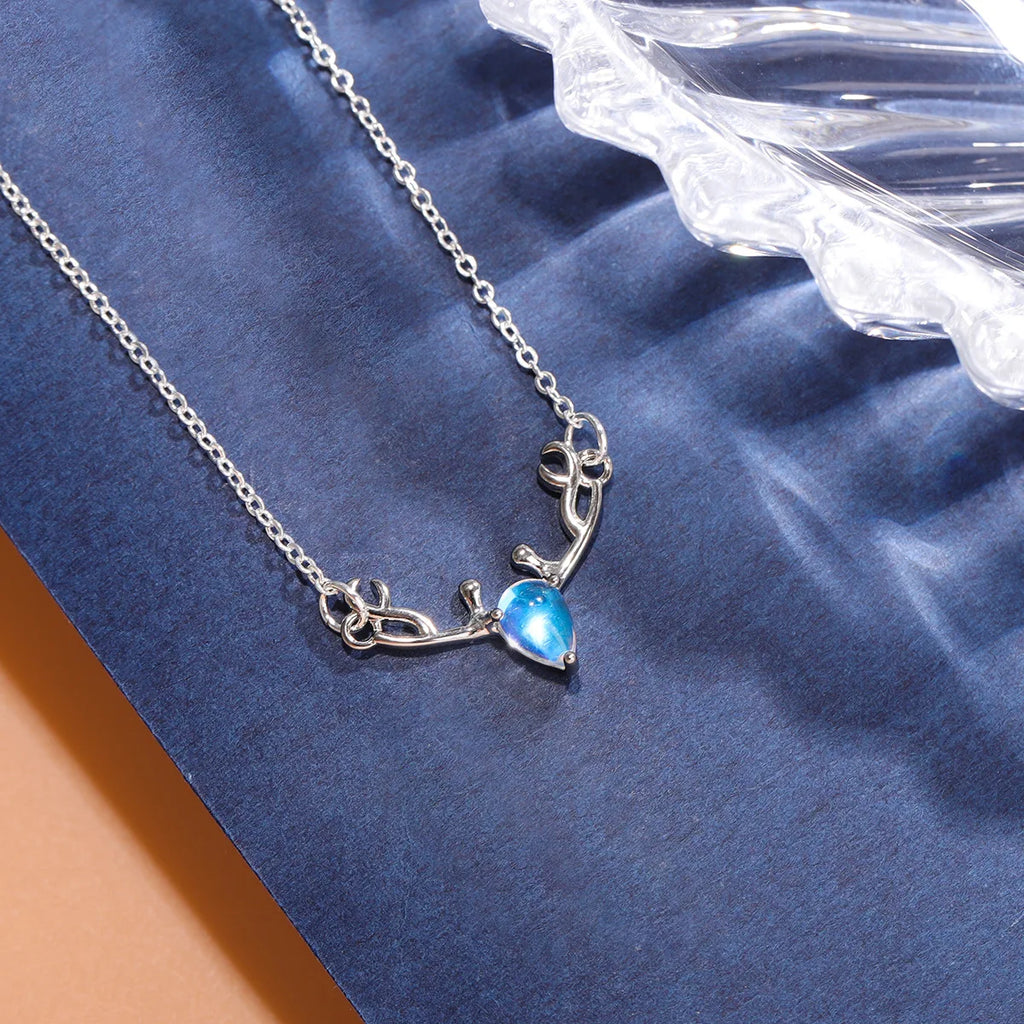 Collar con colgante de asta de ciervo y piedra lunar azul irisada